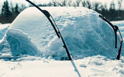 Car's windshield is totally covered with snow and ice, windshield wipers are lifted up