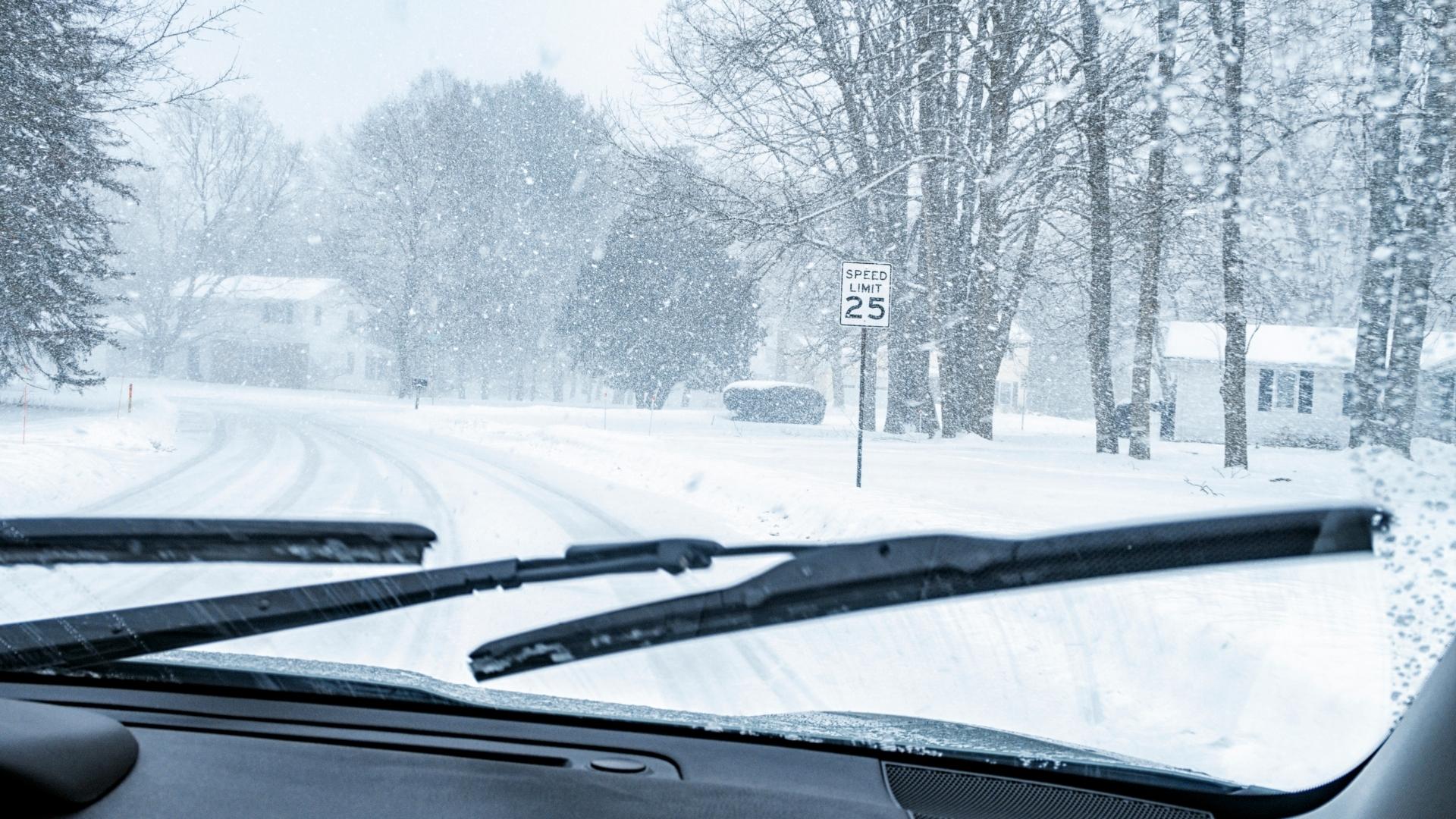 Car is driving during heavy snow, windshield wipers are turned on